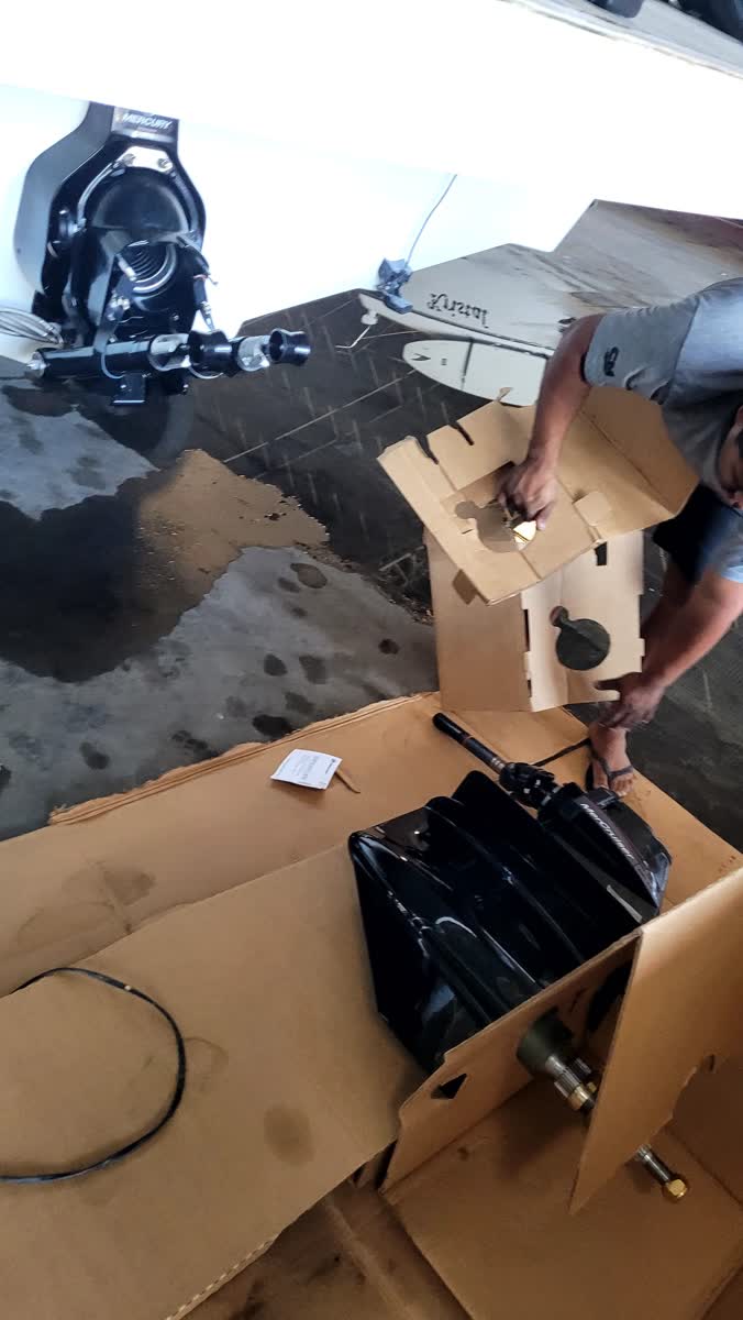 Técnico da HCM desembalando motor Mercury novo — instalação em Angra dos Reis
