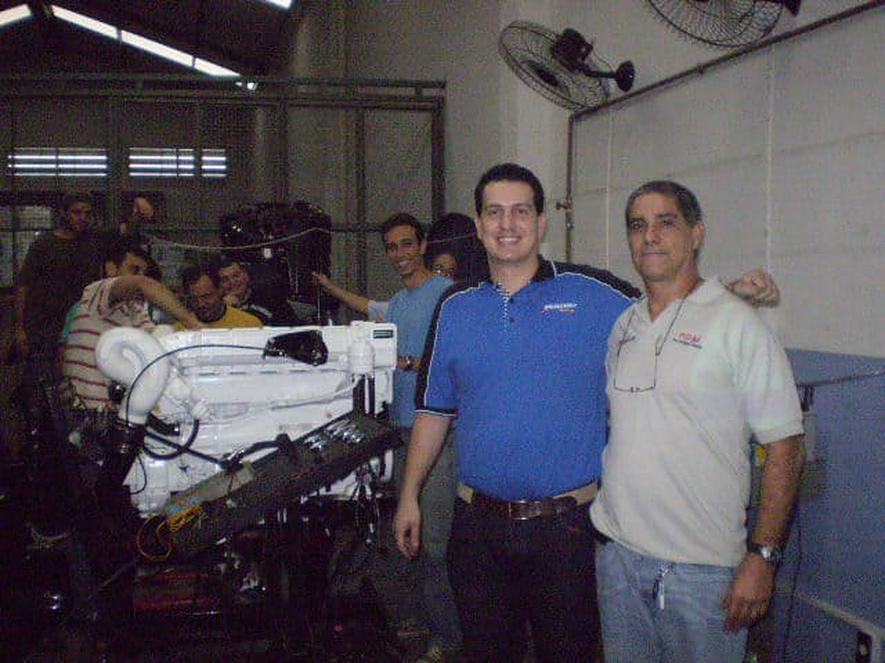 Equipe HCM Mecânica Náutica com motor de popa na oficina